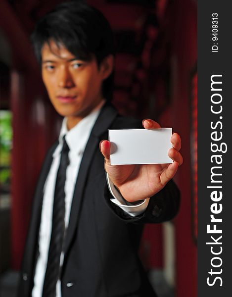 Asian man in business suit with blank card. Asian man in business suit with blank card