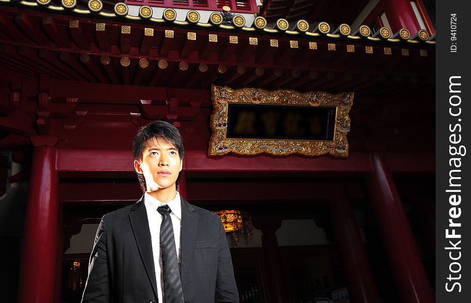Asian man in business suit in chinese temple. Asian man in business suit in chinese temple