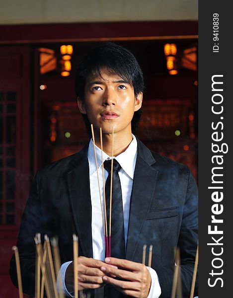 Asian man in business suit in chinese temple. Asian man in business suit in chinese temple