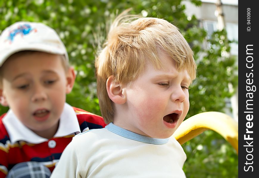 Boys play on a children's playground in the spring. Boys play on a children's playground in the spring