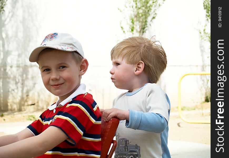 Boys play on a children's playground in the spring. Boys play on a children's playground in the spring