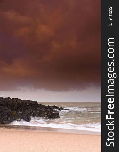 Storm brewing over rocky shore and sandy beach of Winkelspruit near Durban