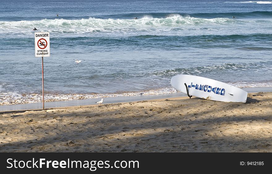 Danger sign on the beach beside a lifegua