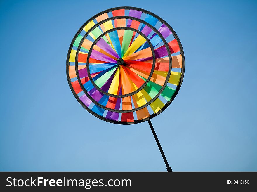 Plastic colourful pinwheel on the blue background