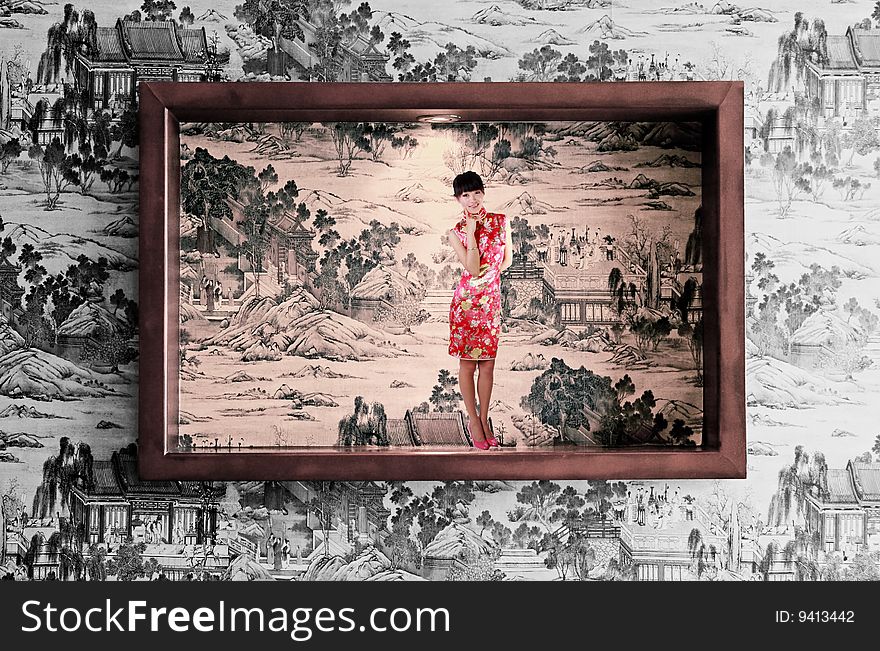 A frame is decorated on the Chinese ancient painting background wall. A Chinese girl in traditional dress stands in the picture. A frame is decorated on the Chinese ancient painting background wall. A Chinese girl in traditional dress stands in the picture.