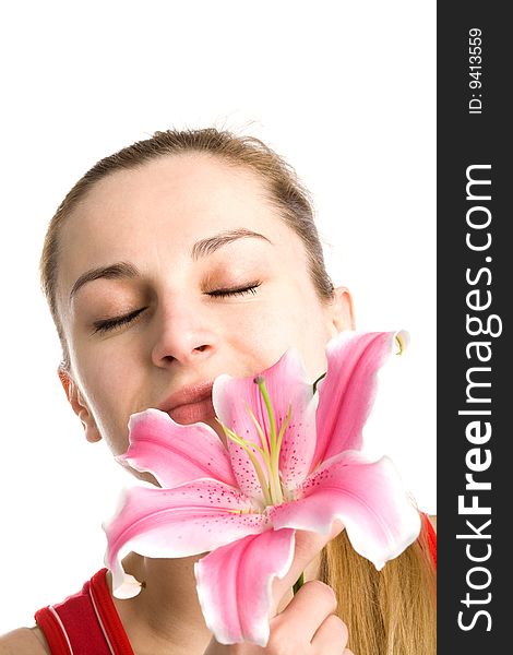 A portrait of a nice blond girl in red with a pink lily near her face on a white background. A portrait of a nice blond girl in red with a pink lily near her face on a white background