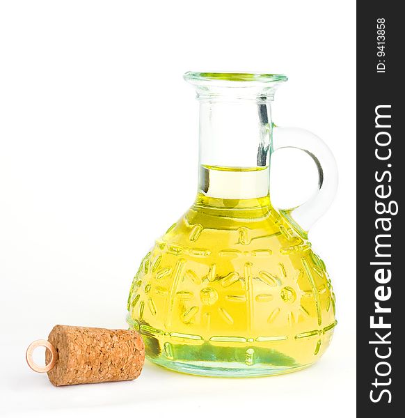 A cork beside a cruet with olive oil on the white background. A cork beside a cruet with olive oil on the white background