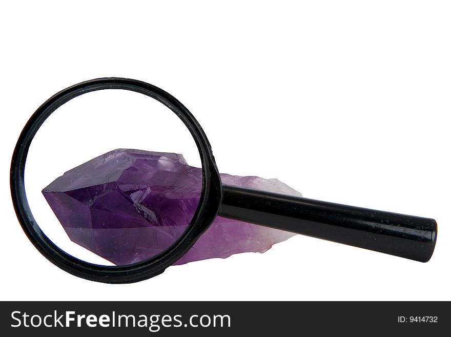 Crystal of amethyst with a magnifier on a white background. Crystal of amethyst with a magnifier on a white background