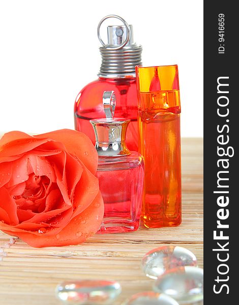 Perfume bottles with flower rose and glass pebbles