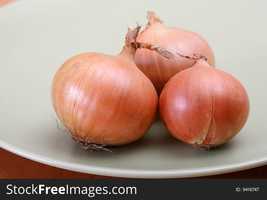 Brown three onions laying on plate