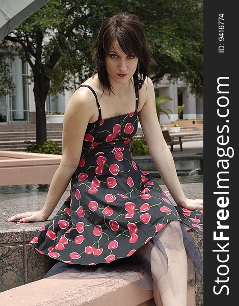 An attractive young girl in a cherry print dress looking at the camera. An attractive young girl in a cherry print dress looking at the camera