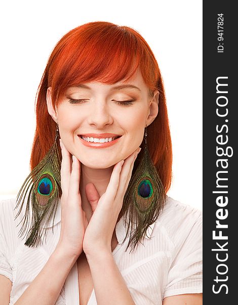 Portrait of young beautiful redhead woman with peacock earrings and closed eyes