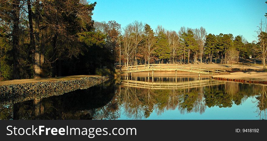 A landscape image with a reflection of a bridge and trees. A landscape image with a reflection of a bridge and trees.