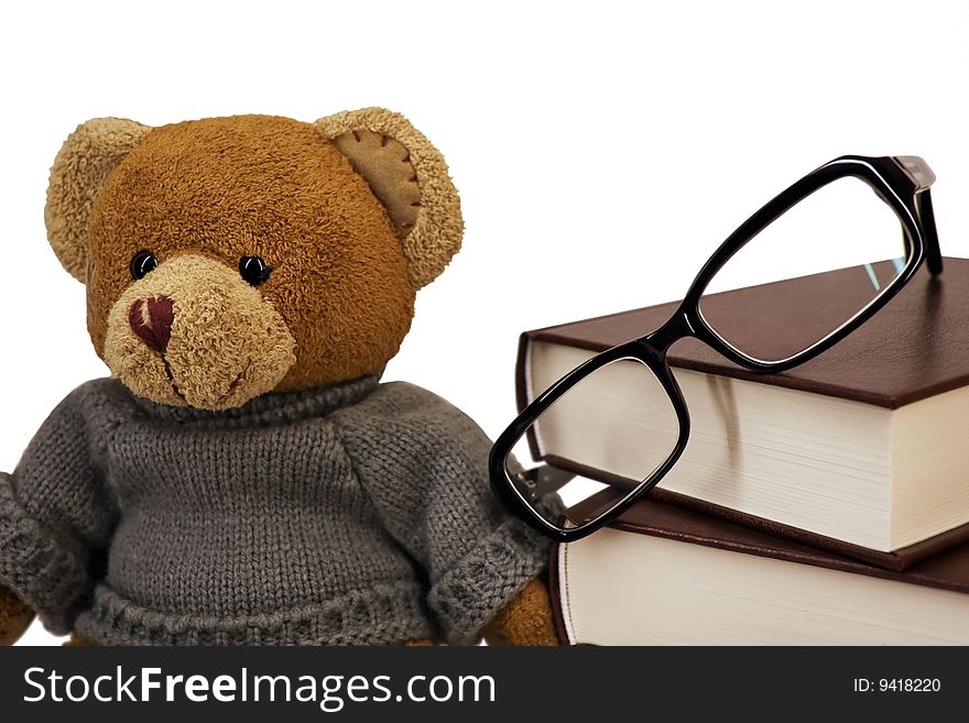 Teddy bear, glasses and a pile of old books