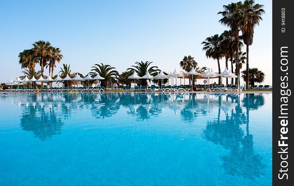 Pool with palms reflecting in the water on a seaside resort