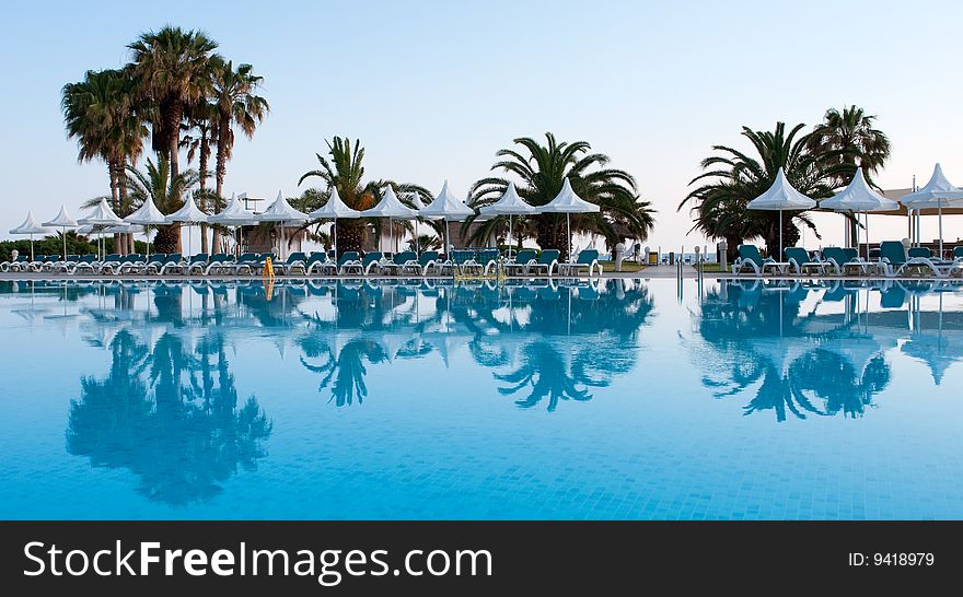 Pool with palms reflecting in the water on a seaside resort