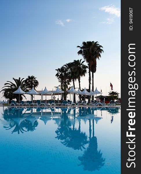 Pool with palms reflecting in the water on a seaside resort