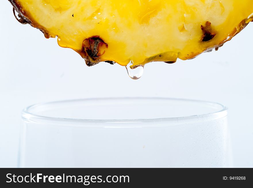 Fresh pineapple drop to glass