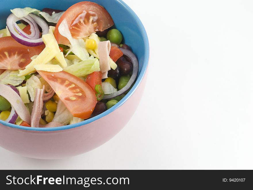 Fresh garden salad in a colorful bowl isolated on white background