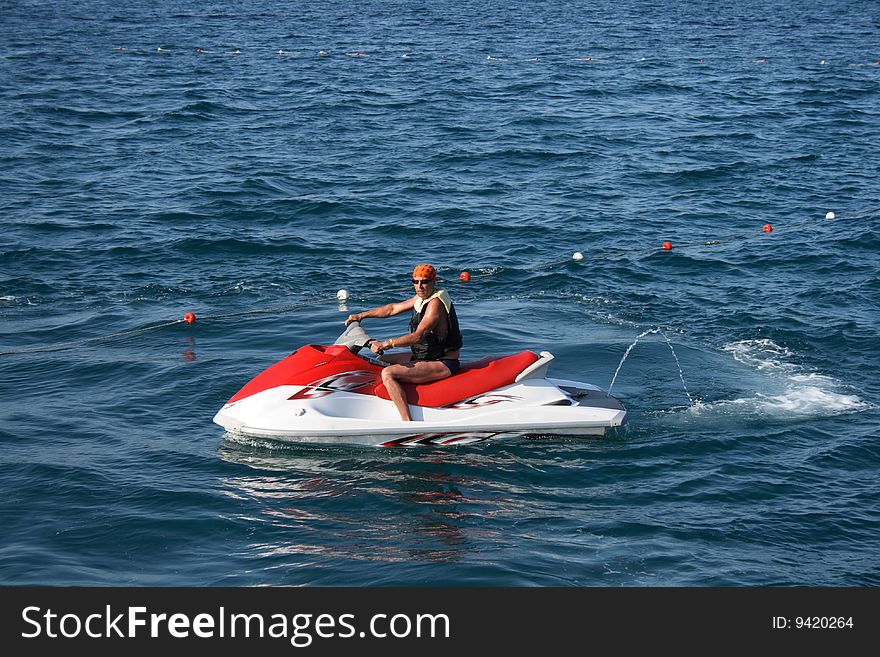 An adult man on a wave runner at sea