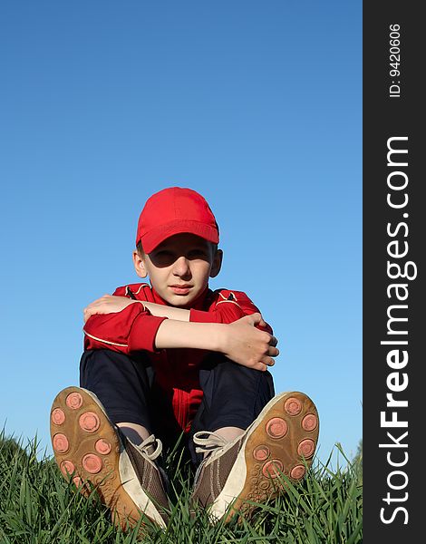 Boy sits on top of the hill. Boy sits on top of the hill