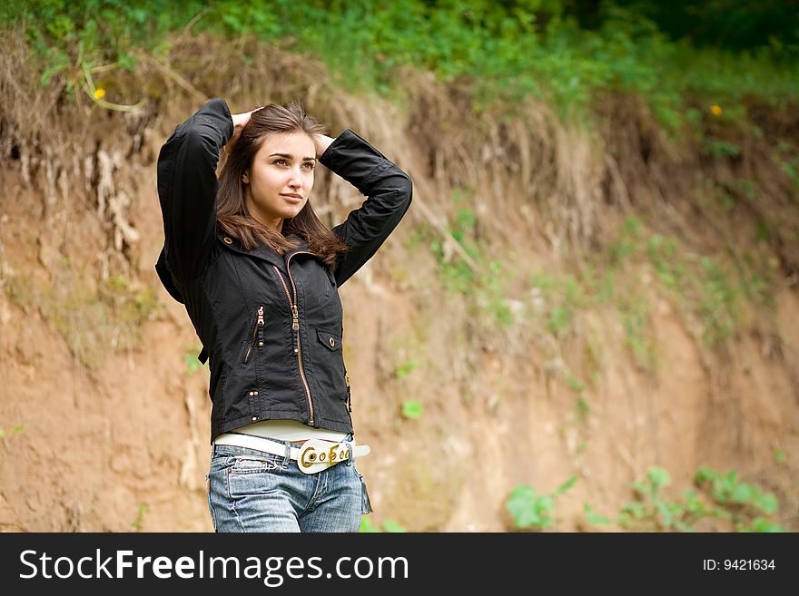 Beautiful girl doing hair up and stay against the bluff. Beautiful girl doing hair up and stay against the bluff