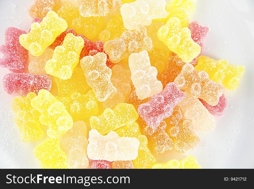 Multicolored jelly sweets covered by sugar in the shape of bear cubs. Multicolored jelly sweets covered by sugar in the shape of bear cubs.