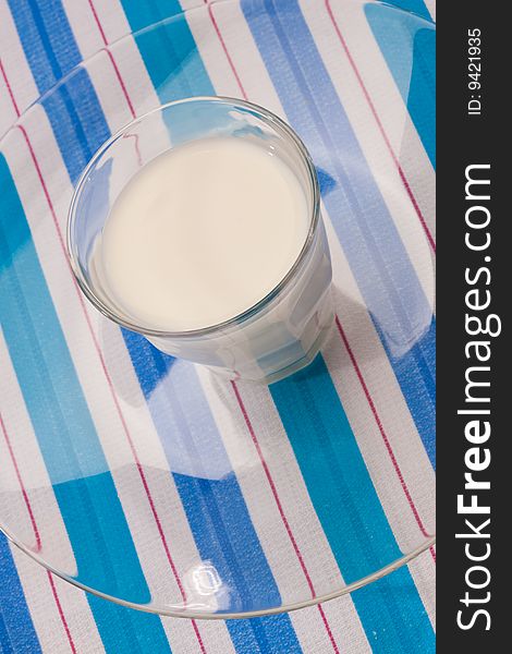 Food series: full glass of milk on stripped table-cloth