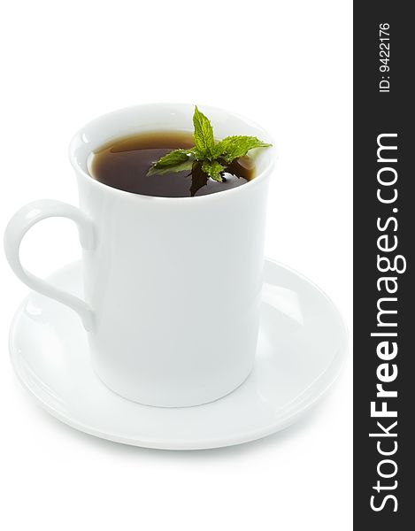 Cup of black tea on the saucer with mint leaves. Cup of black tea on the saucer with mint leaves