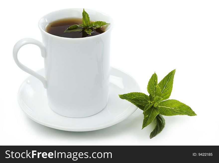 Cup of black tea on the saucer with mint leaves. Cup of black tea on the saucer with mint leaves