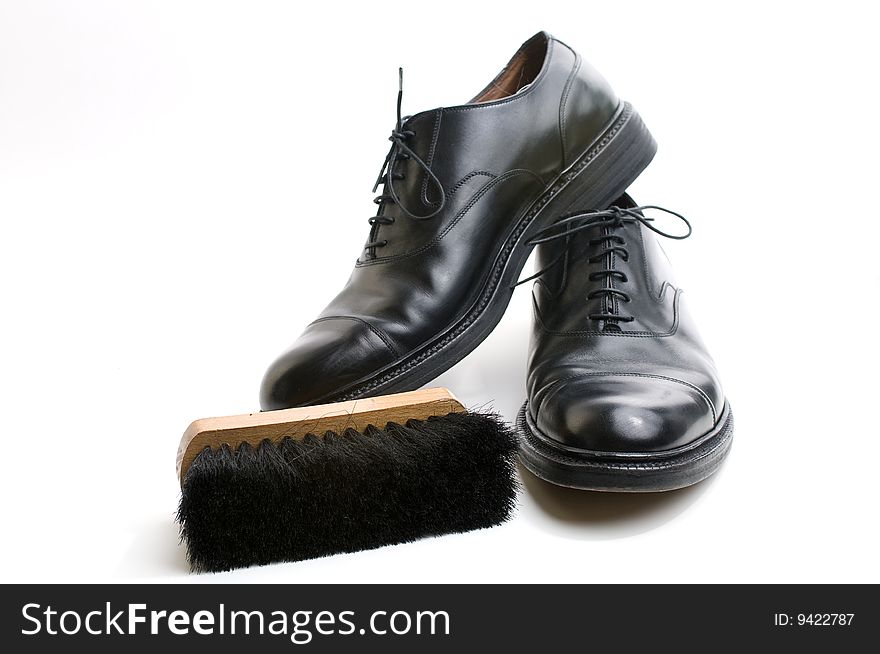 Black shoes and brush on white background