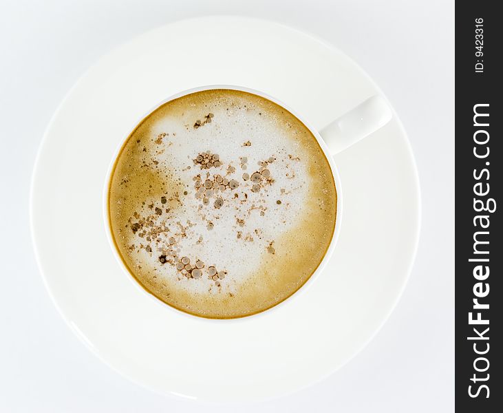 Cup of coffee, latte or cappuccino on a white plate topped with cocoa or chocolate from above isolated on white background