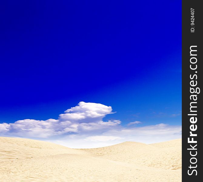 Sun dunes in desert under blue sky