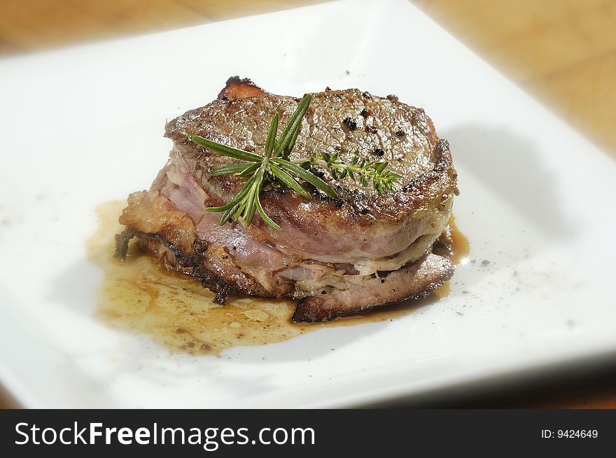 Beefsteak with the rosemary on the white plate