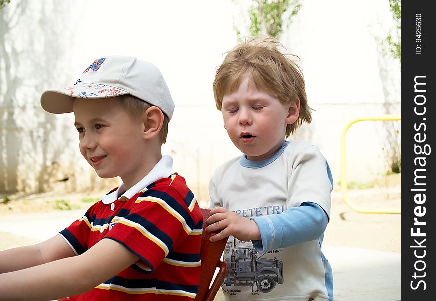 Boys play on a children's playground in the spring. Boys play on a children's playground in the spring