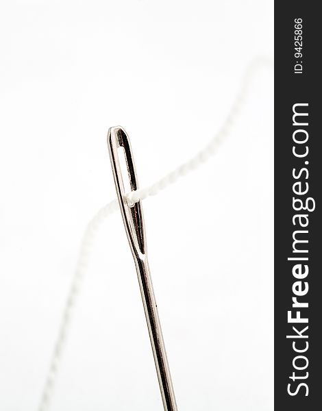 Needle with white thread, isolated on white background. Needle with white thread, isolated on white background