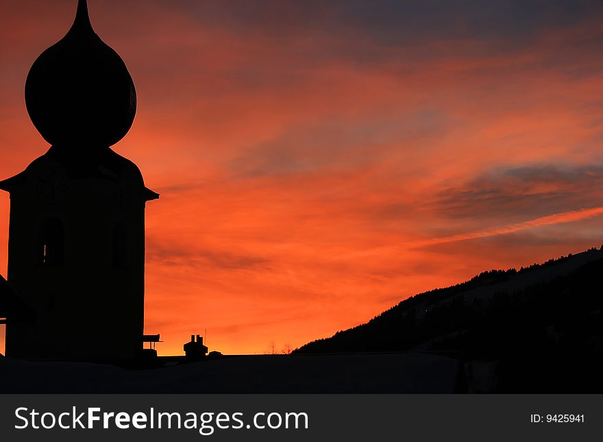 A beautiful sunset behind a church in the Alps. A beautiful sunset behind a church in the Alps.