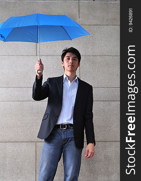 Sasual Asian man with blue umbrella. Sasual Asian man with blue umbrella.