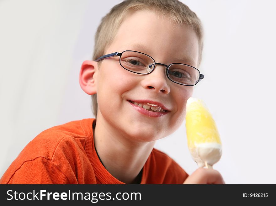 Boy eating yellow ice cream. Boy eating yellow ice cream.