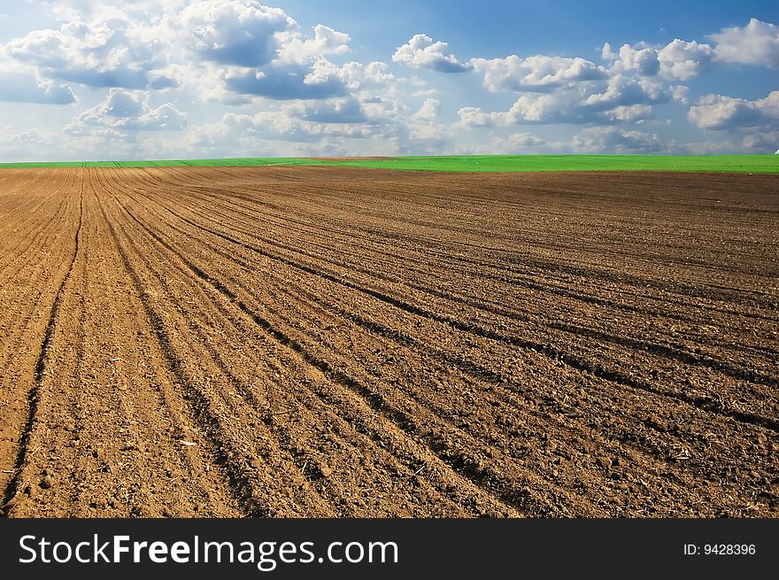 Beautiful landscape image of ploughland and dramatic cloudy sky.