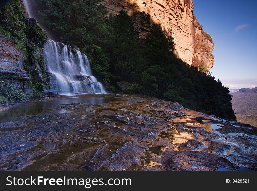 Misty Katoomba waterfalls in Blue mountains National park in NSW, Australia. Horizontal composition with distant mountains. Misty Katoomba waterfalls in Blue mountains National park in NSW, Australia. Horizontal composition with distant mountains.