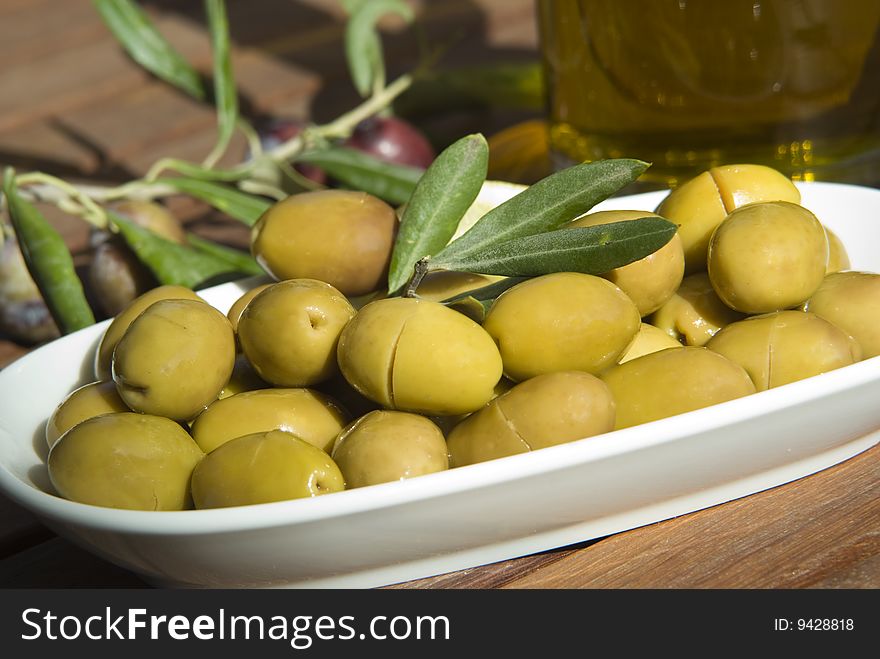 Fresh green olives and olive branch