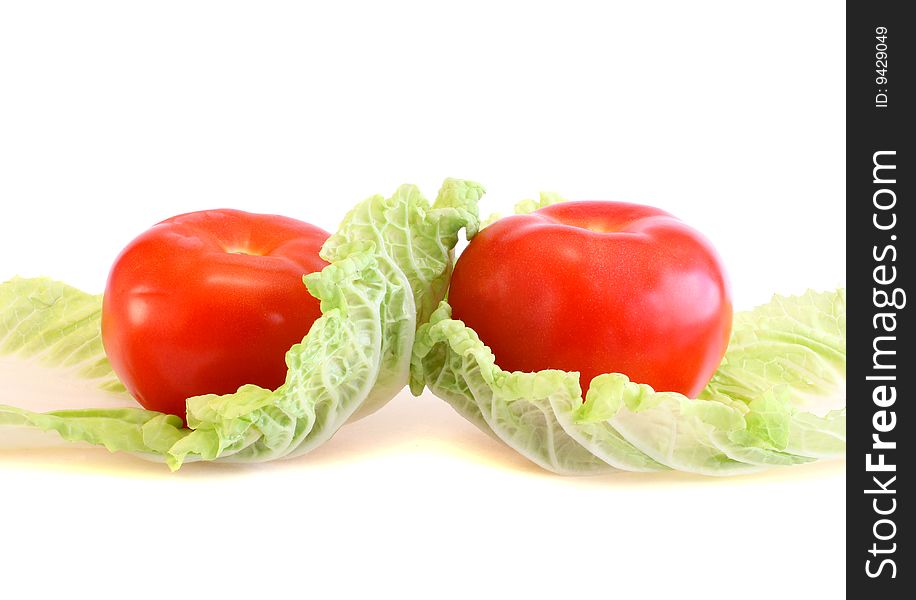 Two tomatoes and salad on a white background, it is isolated.