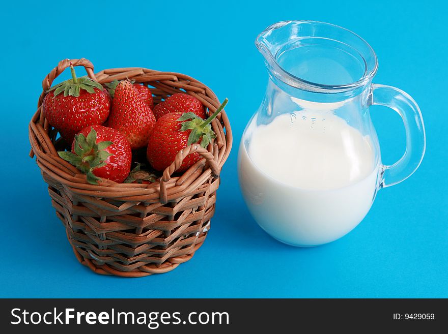 Strawberries in a wicker basket  and jug of milk or yoghurt. Strawberries in a wicker basket  and jug of milk or yoghurt.