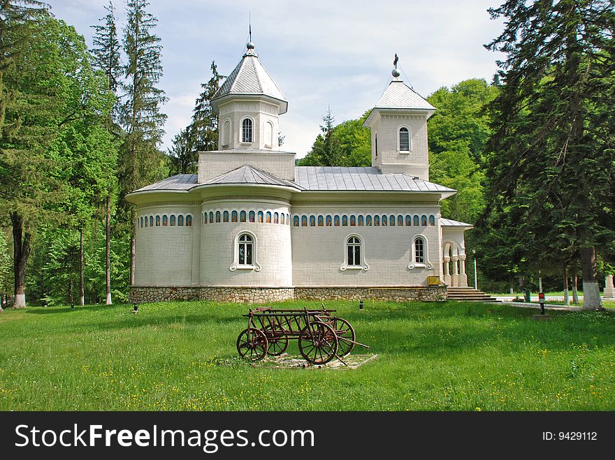 Romanian  orthodox church and an old waggon