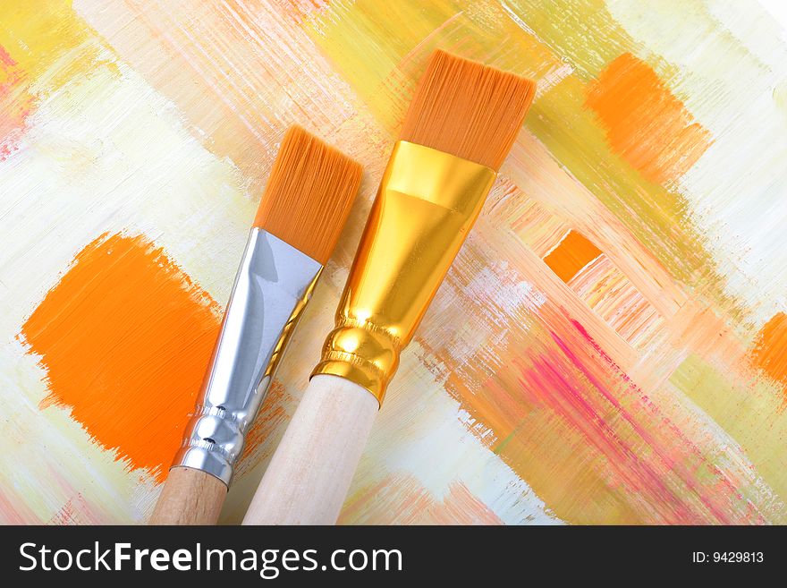 New paintbrushes on painted background .