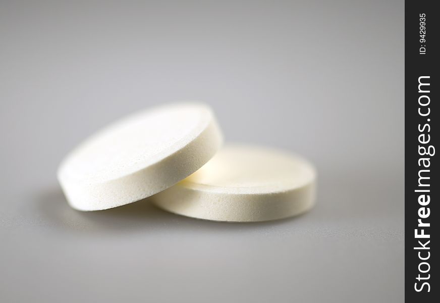 Two white pills in focus