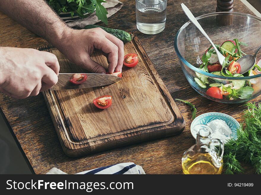 Man Preparing Breakfast From Salad In Home Kitchen