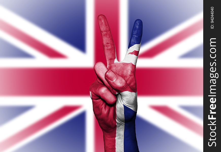 Hands with peace sign painted against British Union Jack flag. Hands with peace sign painted against British Union Jack flag.