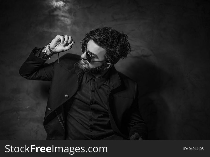 Man wearing sunglasses dancing in studio portrait in black and white. Man wearing sunglasses dancing in studio portrait in black and white.